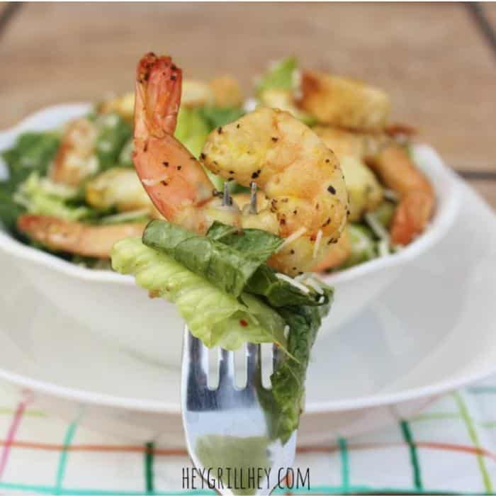 A bowl full of salad topped with shrimp