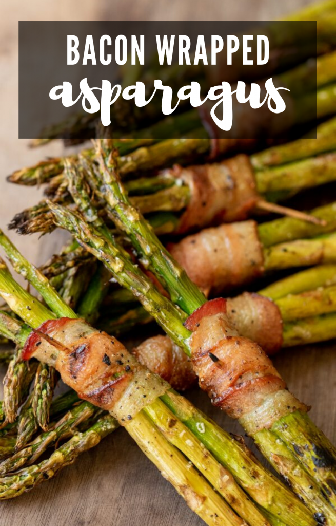 Asparagus clusters wrapped in bacon on top of a wooden cutting board