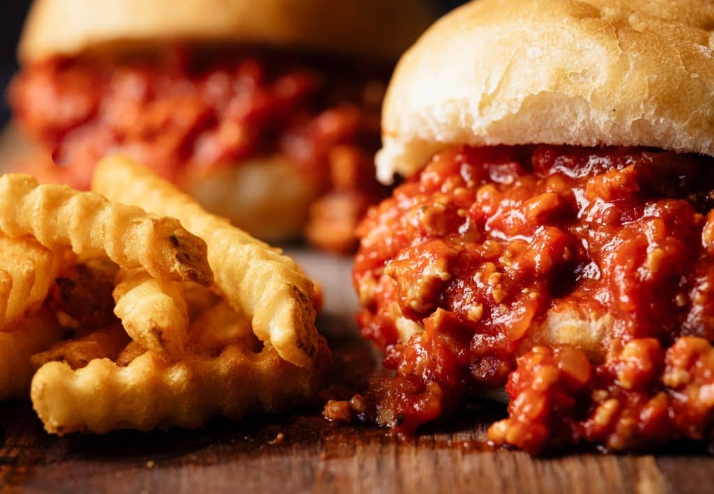 Turkey sloppy joes next to a pile of crinkle cut fries.