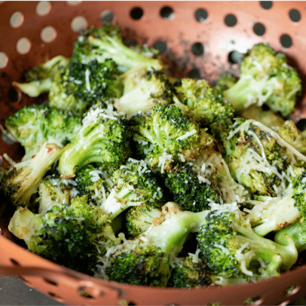 Garlic Parmesan grilled broccoli in a copper vegetable basket.
