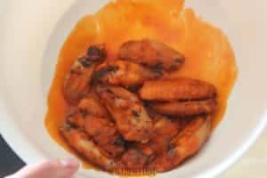 cooked chicken wings in a white bowl with brown sauce