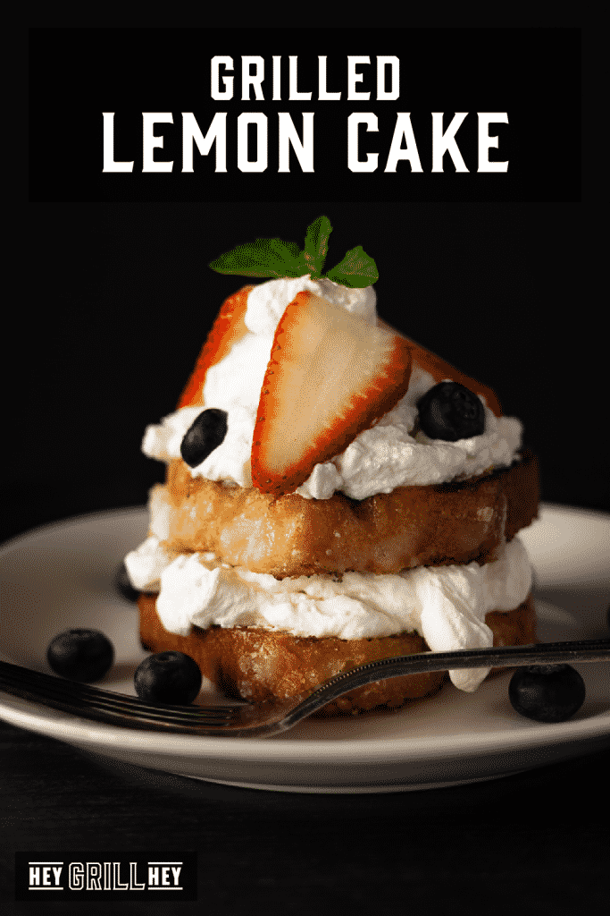 Grilled lemon cake topped with whipped cream and fresh blueberries and strawberries with text overlay - Grilled Lemon Cake.