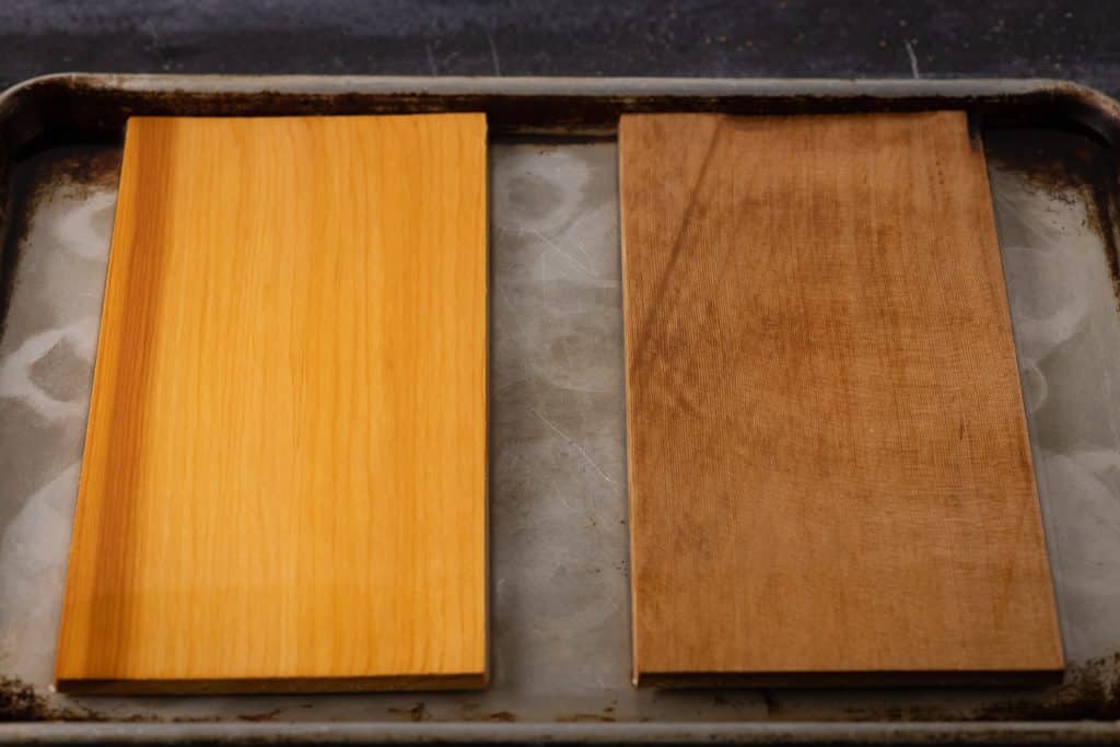 Two cedar planks on a metal baking dish.