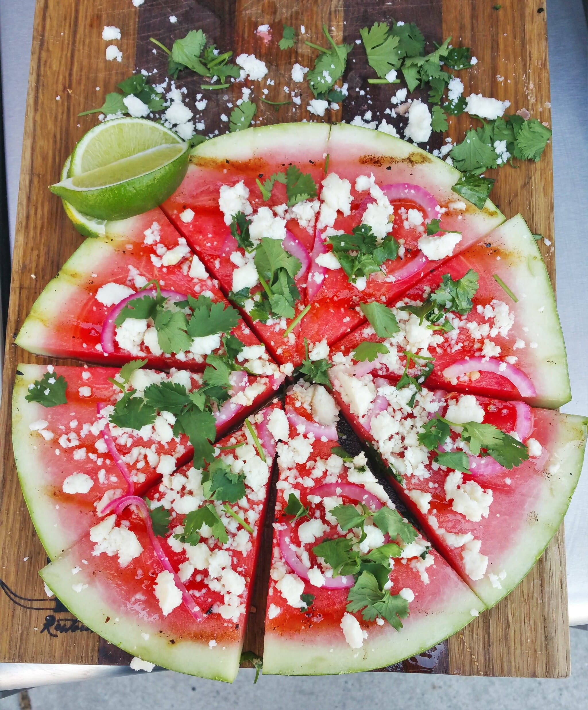 Grilled Watermelon Pizza with lime, honey, red onion, queso fresco and cilantro.