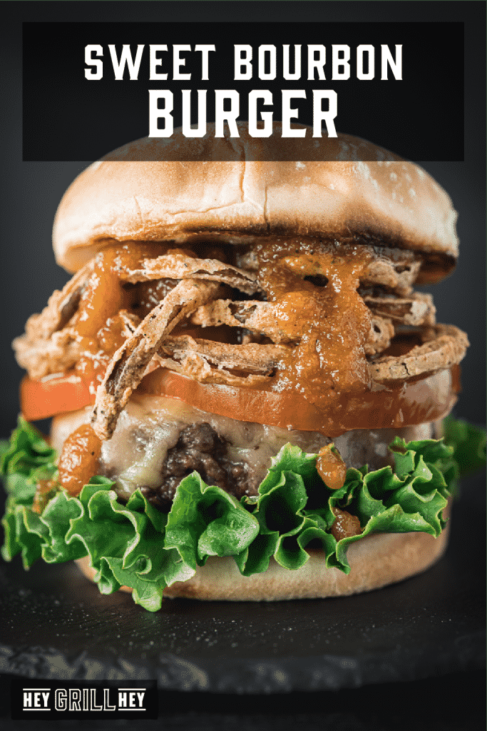 Bourbon burger topped with lettuce, tomato, crispy onion straws and bourbon BBQ sauce with text overlay - Sweet Bourbon Burger.