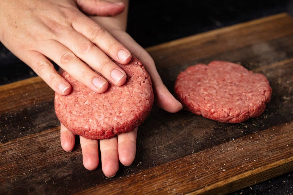Grass fed beef being formed into a burger patty.