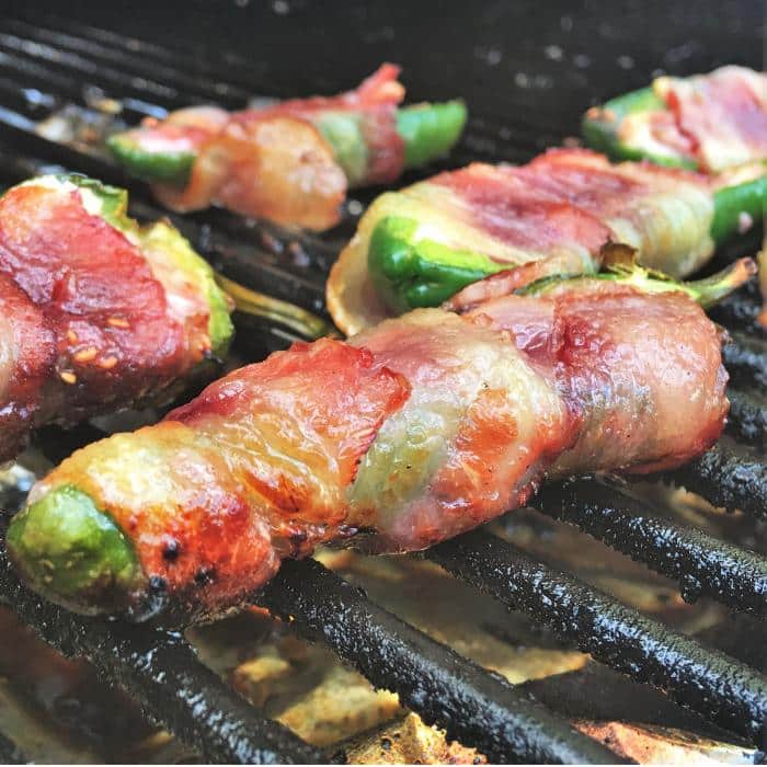 raspberry cream cheese jalapeno poppers on a grill grate.