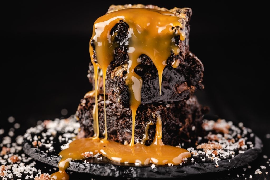 Stack of smoked brownies with caramel drizzling down them.