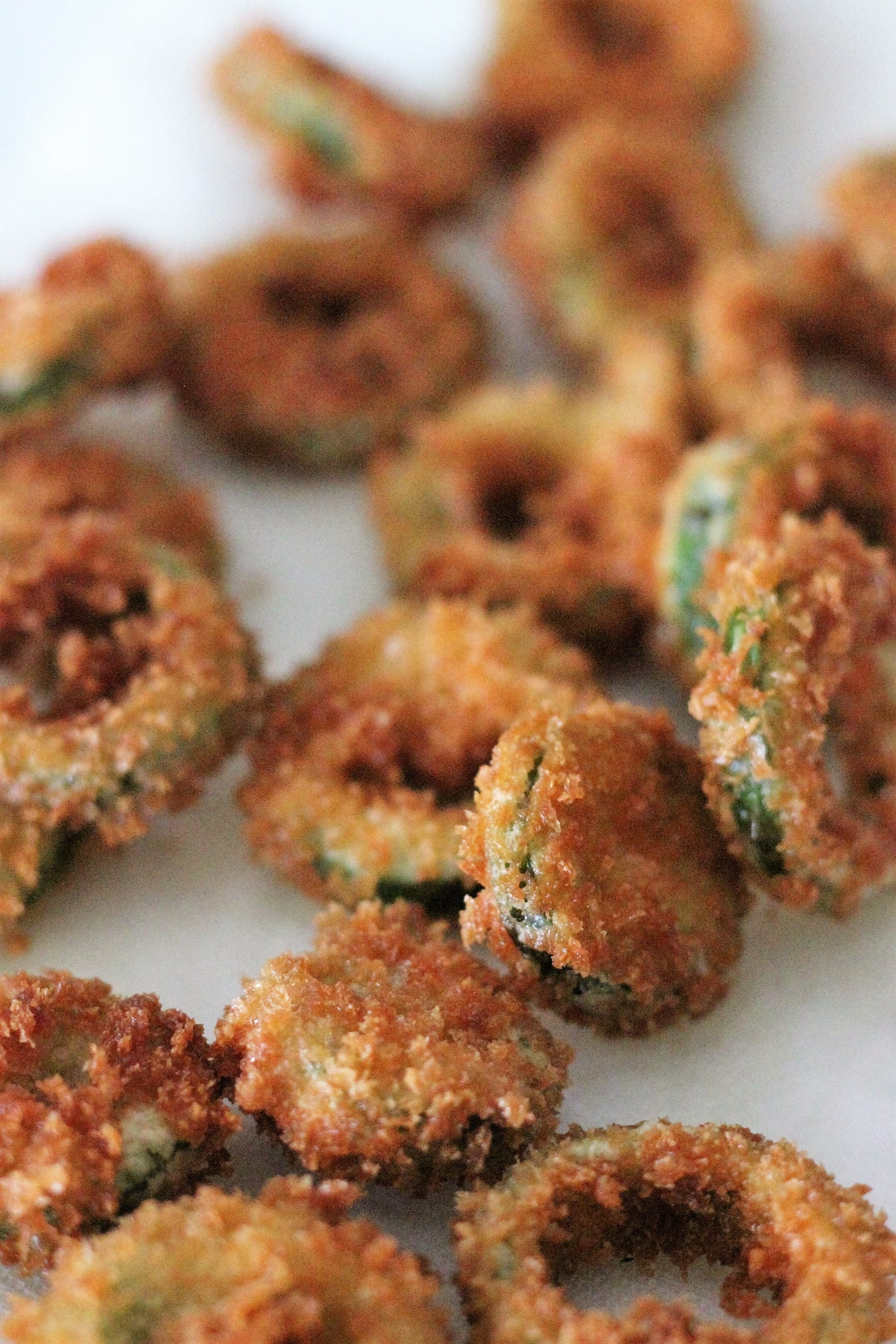 fried jalapeno rings on a white surface.