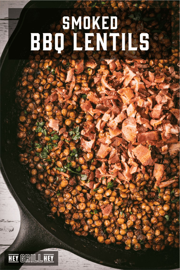 BBQ baked lentils in a cast iron skillet topped with bacon with text overlay - Smoked BBQ Lentils.