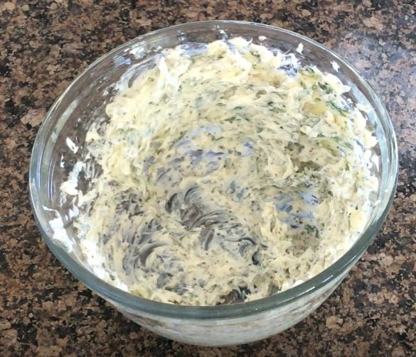 bowl of herbed butter on a granite countertop