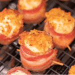 Pineapple cream cheese stuffed bacon wrapped pig shots on a cooling rack.