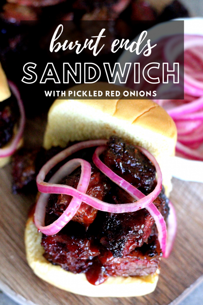 Burnt ends stacked on a potato roll and topped with pickled red onions. Photo includes decorative text.