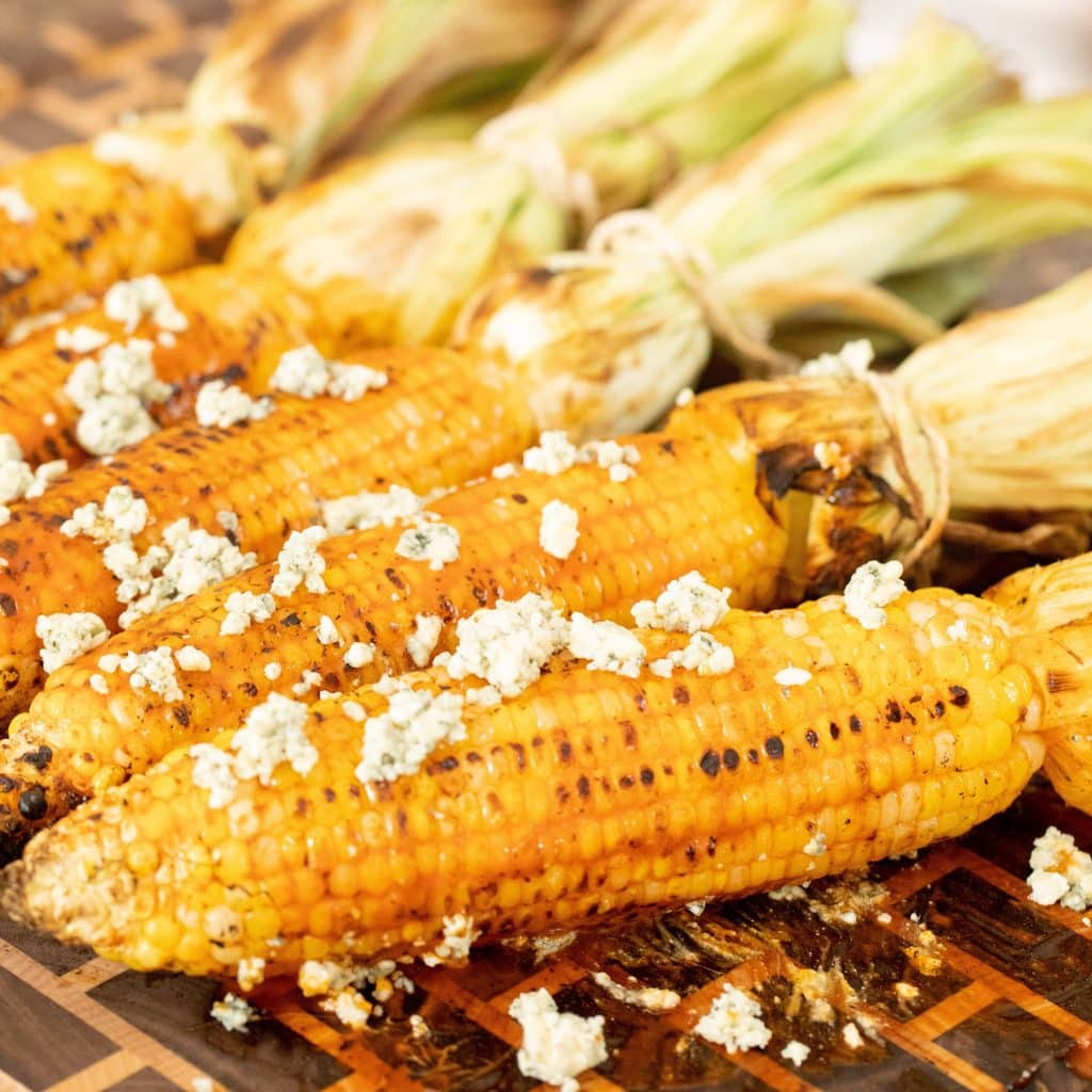 Grilled Corn on the cob top with crumbled white cheese.