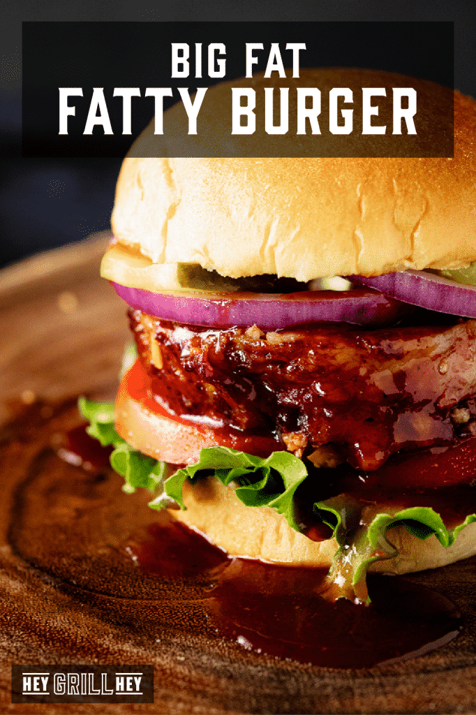 Fatty burger topped with lettuce, onion, and tomato with text overlay - Big Fat Fatty Burger.