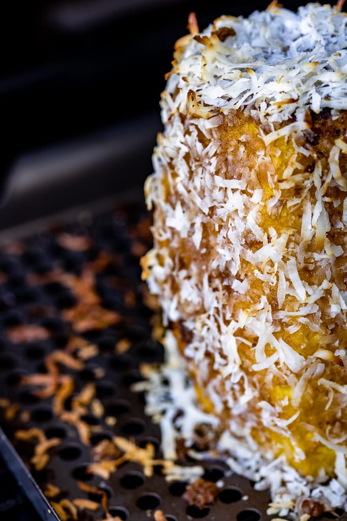 Pineapple covered with dark brown sugar and shredded coconut.