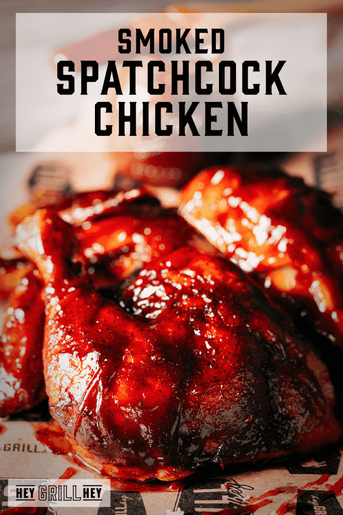 Smoked spatchcock chicken covered in a cherry chipotle BBQ sauce on a wooden cutting board with text overlay - Smoked Spatchcock Chicken.