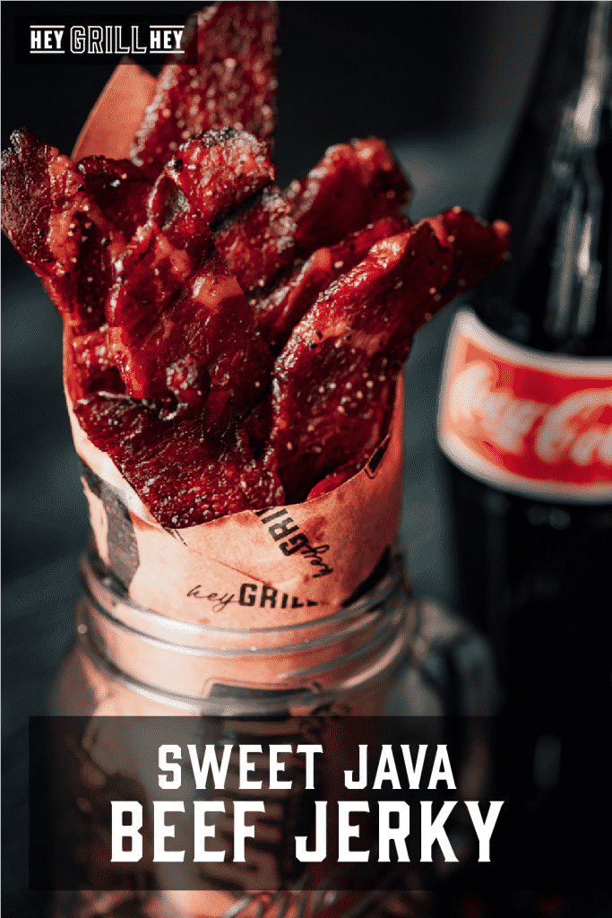 Sweet java beef jerky wrapped in Hey Grill Hey butcher paper in a glass mason jark with a bottle of Coca-Cola in the background.