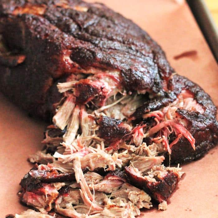 Smoked pulled pork shoulder on peach butcher paper.