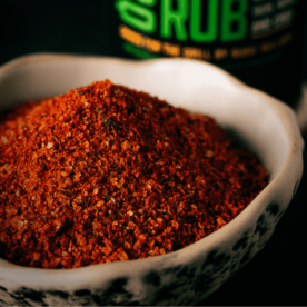 Homemade fiesta rub in a bowl with a bottle of Fiesta Rub in the background.