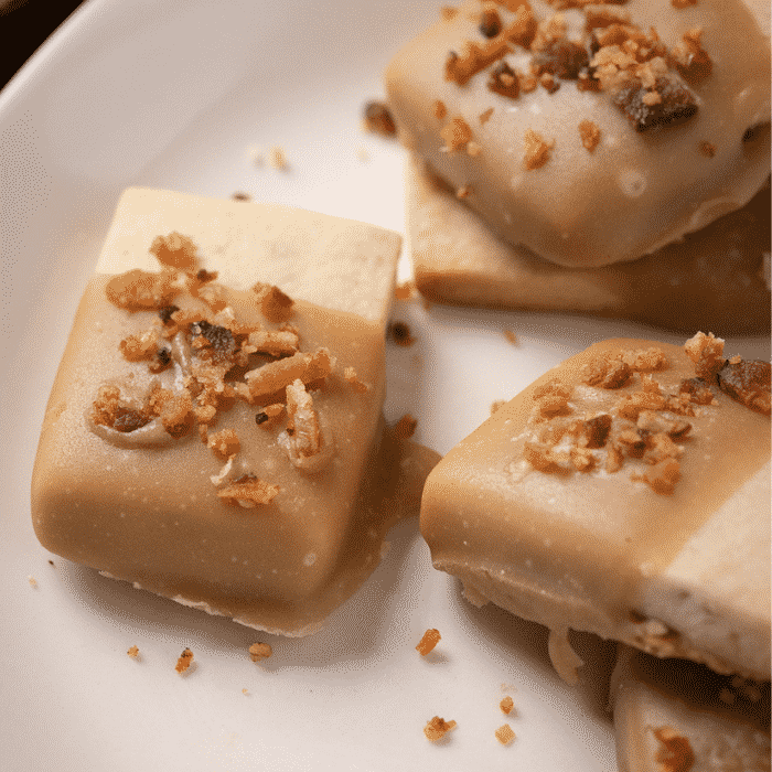 Maple dipped shortbread cookies on a white plate.
