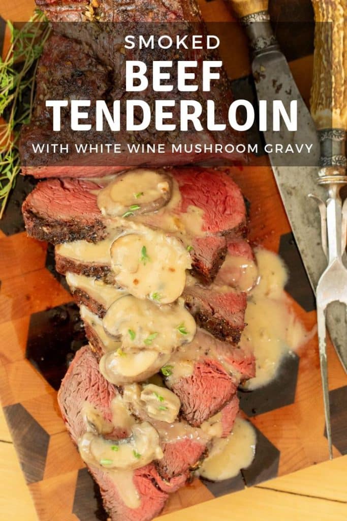 smoked beef tenderloin topped with white wine mushroom gravy on a wooden cutting board.