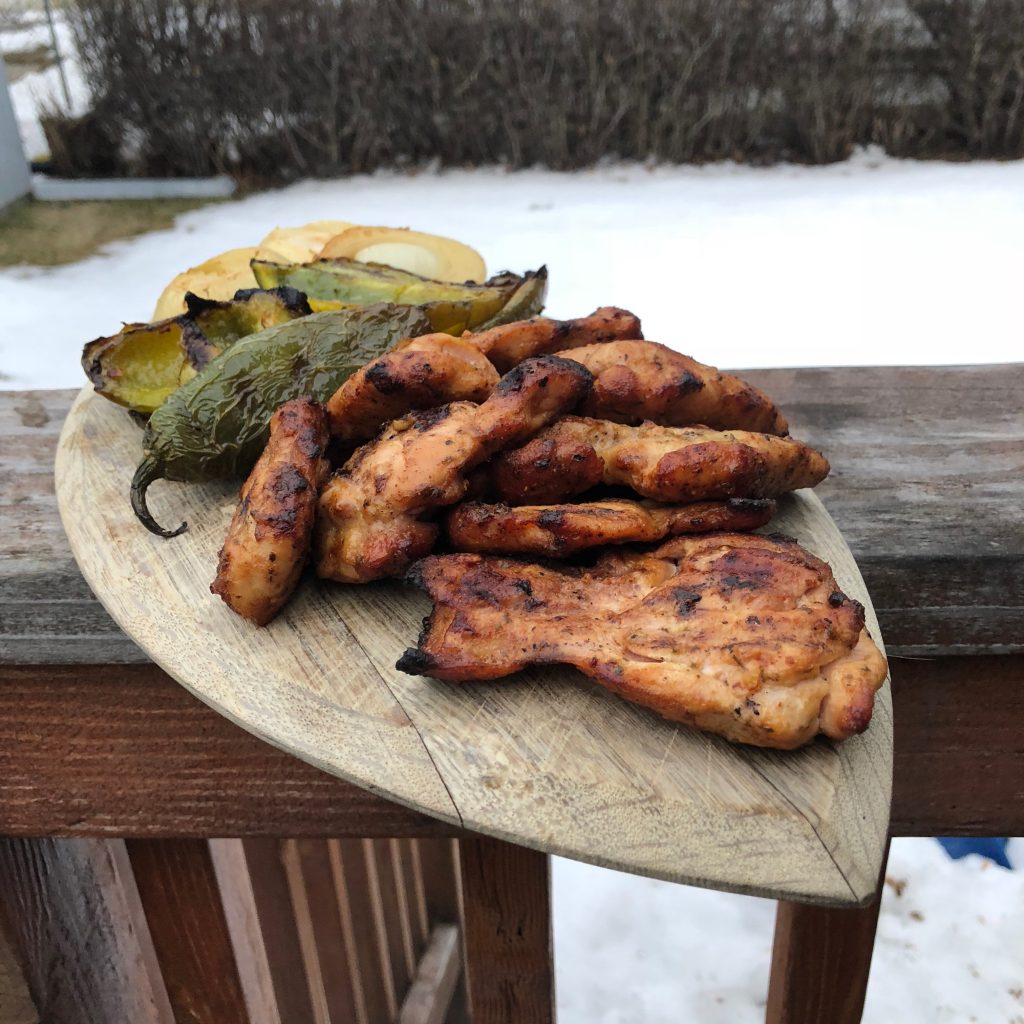 Grilled chicken thighs displayed on a cutting board