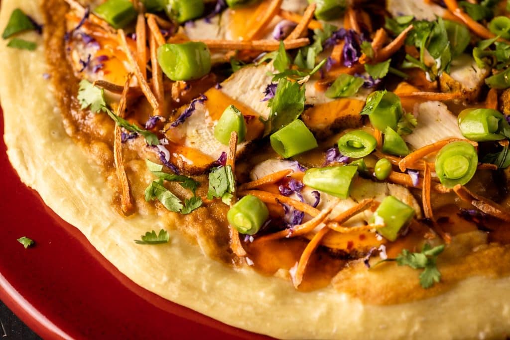 Thai grilled chicken pizza on a serving dish.