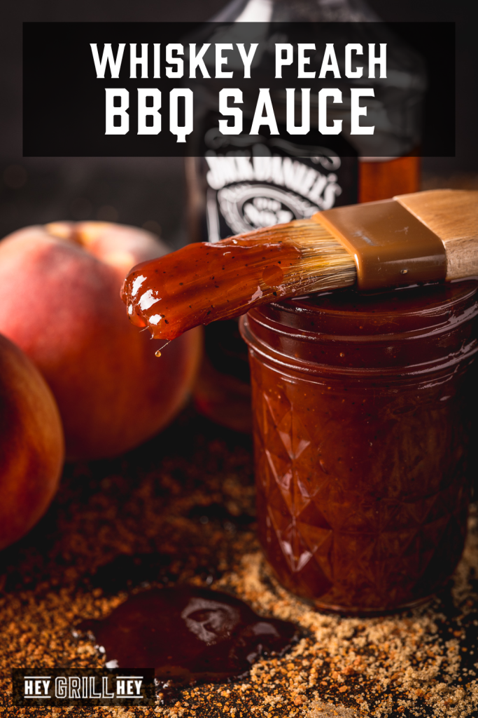Whiskey peach BBQ sauce dripping off a sauce brush with text overlay - Whiskey Peach BBQ Sauce.