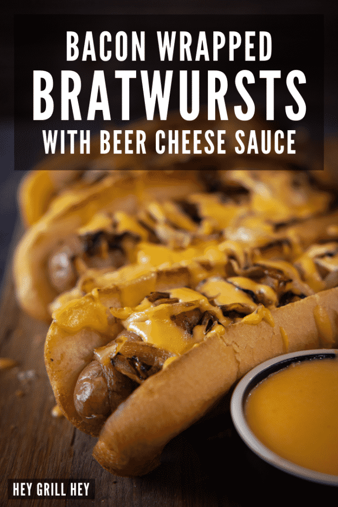 Bacon wrapped brats in a row drizzled with beer cheese sauce. Text overlay reads: Bacon Wrapped Bratwursts with Beer Cheese Sauce.