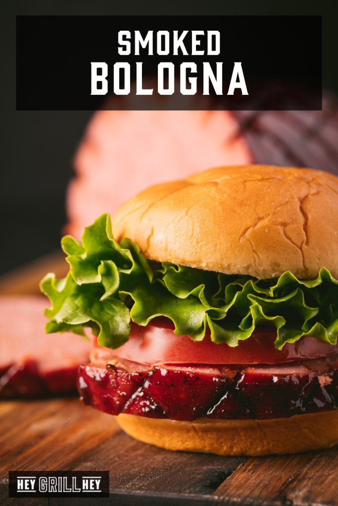 Smoked bologna sandwich on a cutting board with text overlay - Smoked Bologna.