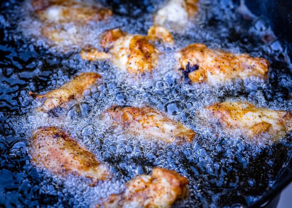 Smoked chicken wings in frying oil.