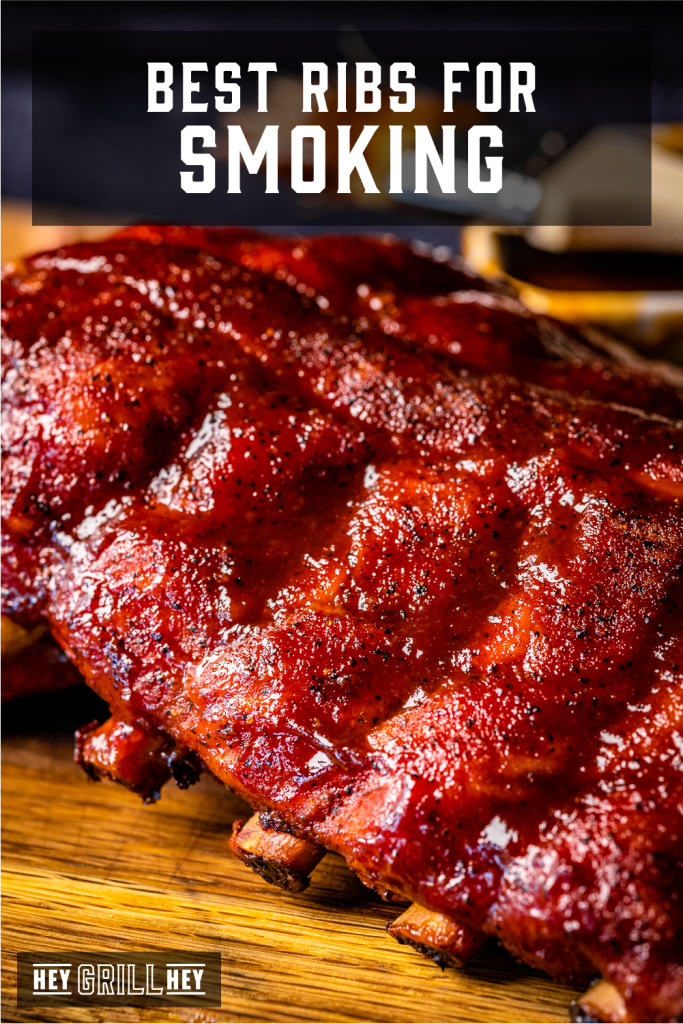Rack of baby back ribs on a wooden cutting board with text overlay - Best Ribs for Smoking.