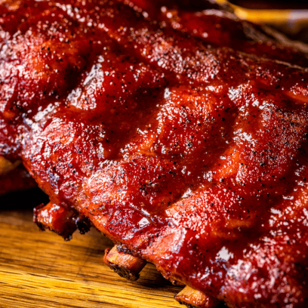 Rack of baby back ribs on a wooden cutting board.