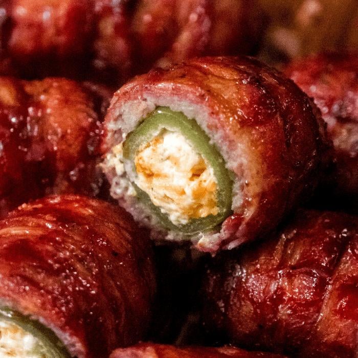 Close up of sliced and stacked bacon wrapped armadillo eggs.