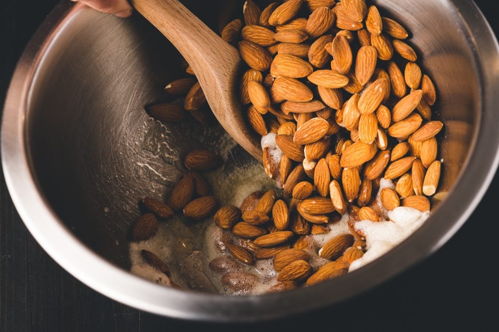 Almonds being tossed in egg whites.