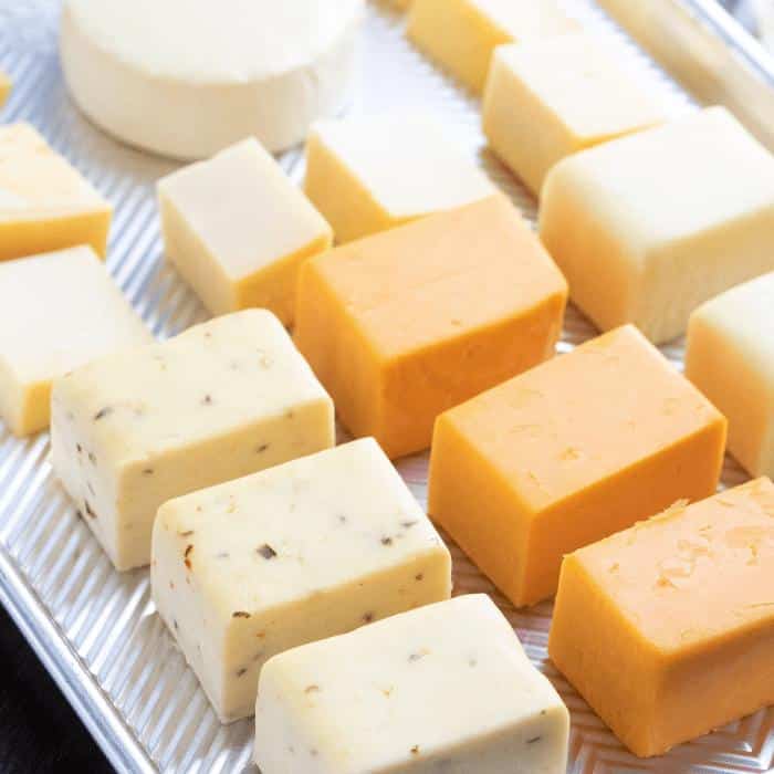 Cubes of smoked cheese on a metal baking dish.