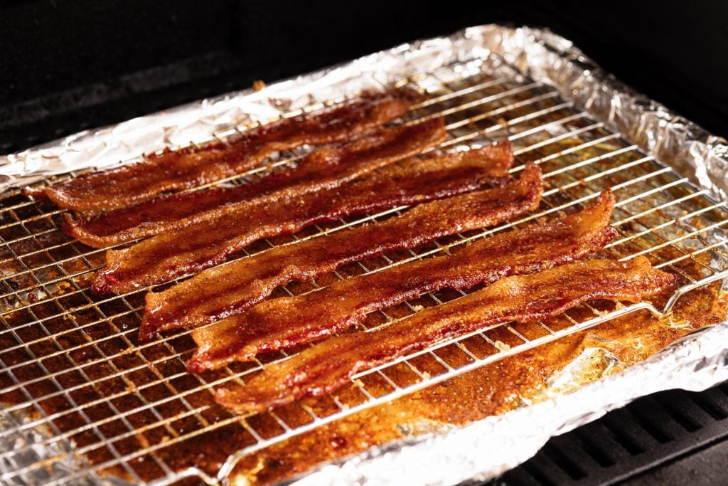 Seasoned bacon on the smoker.