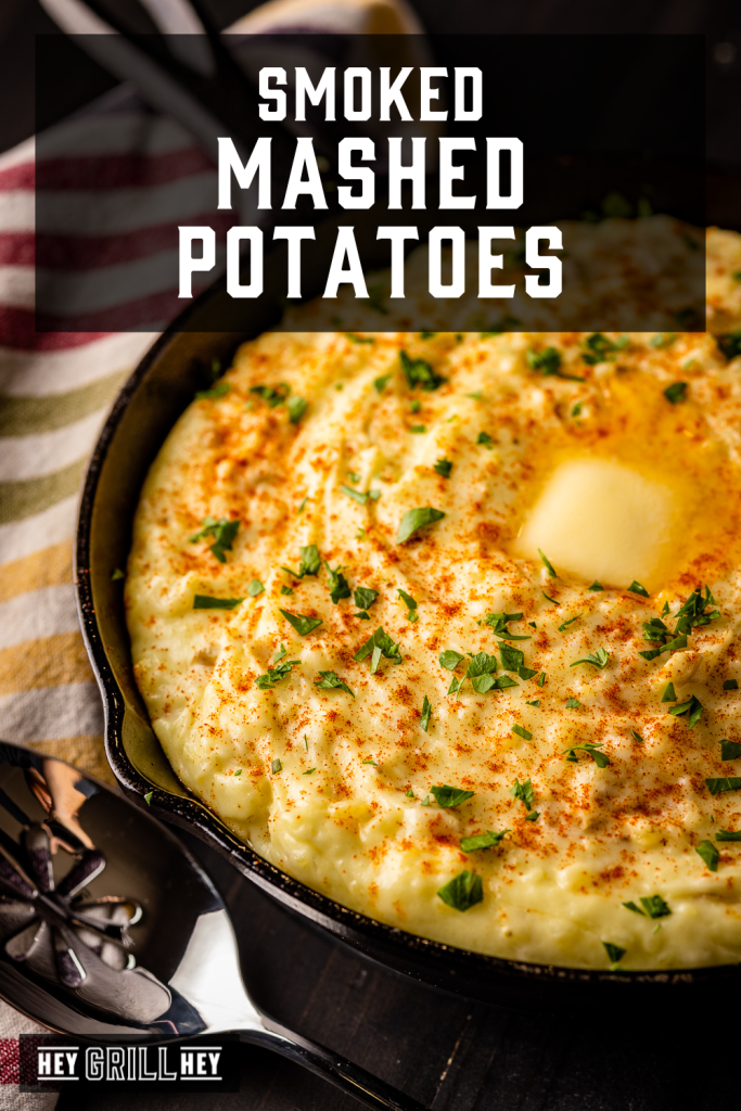 Smoked mashed potatoes in a cast iron skillet with text overlay - Smoked Mashed Potatoes.