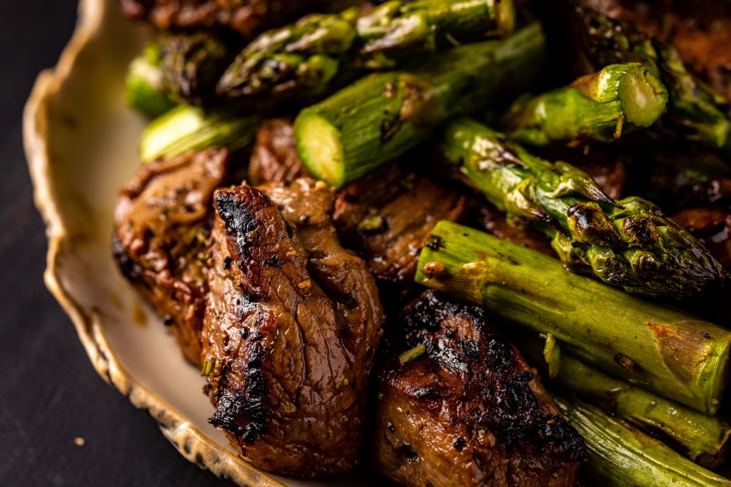 Grilled steak and asparagus on a serving platter.