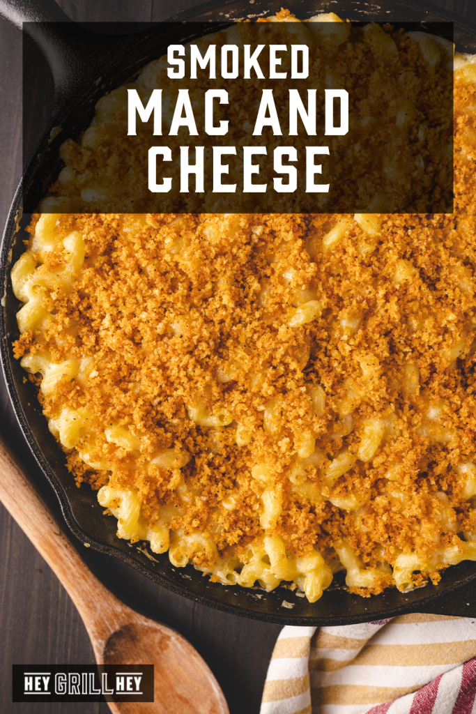 Smoked mac and cheese in a cast iron skillet with text overlay - Smoked Mac and Cheese.