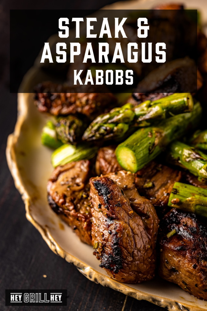Grilled steak and asparagus on a serving platter with text overlay - Steak and Asparagus Kabobs.