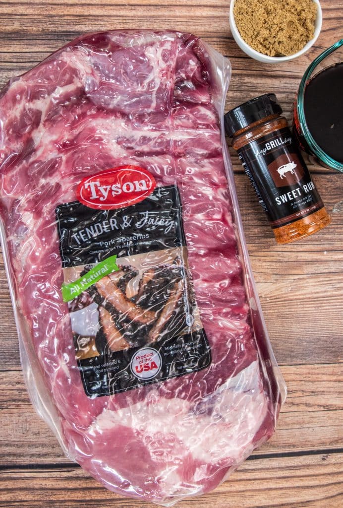 pack of Tyson pork spareribs and sweet rub on cutting board.
