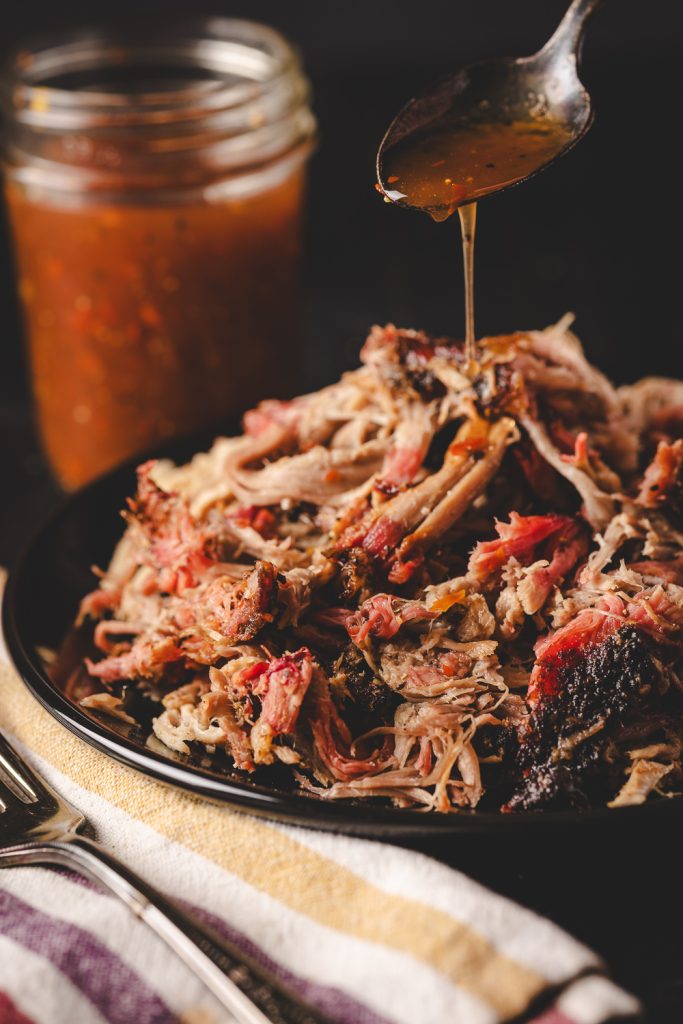 Carolina vinegar sauce being drizzled over pulled pork.