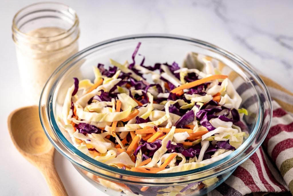 Chopped cabbage and carrots in a glass bowl.