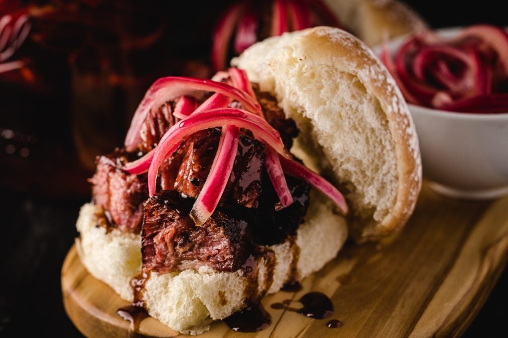 Pickled red onions on a pulled pork sandwich.