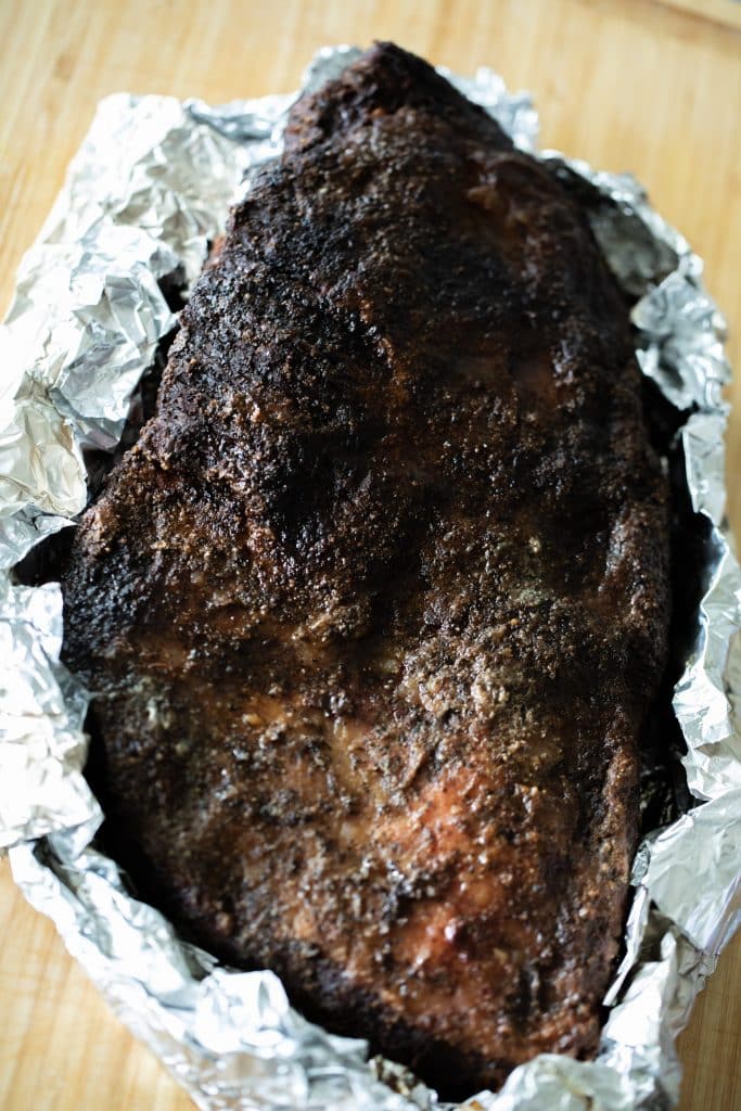 whole smoked beef brisket on foil.
