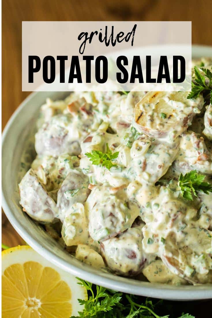 grilled potato salad in a stoneware bowl with parsley and lemon.