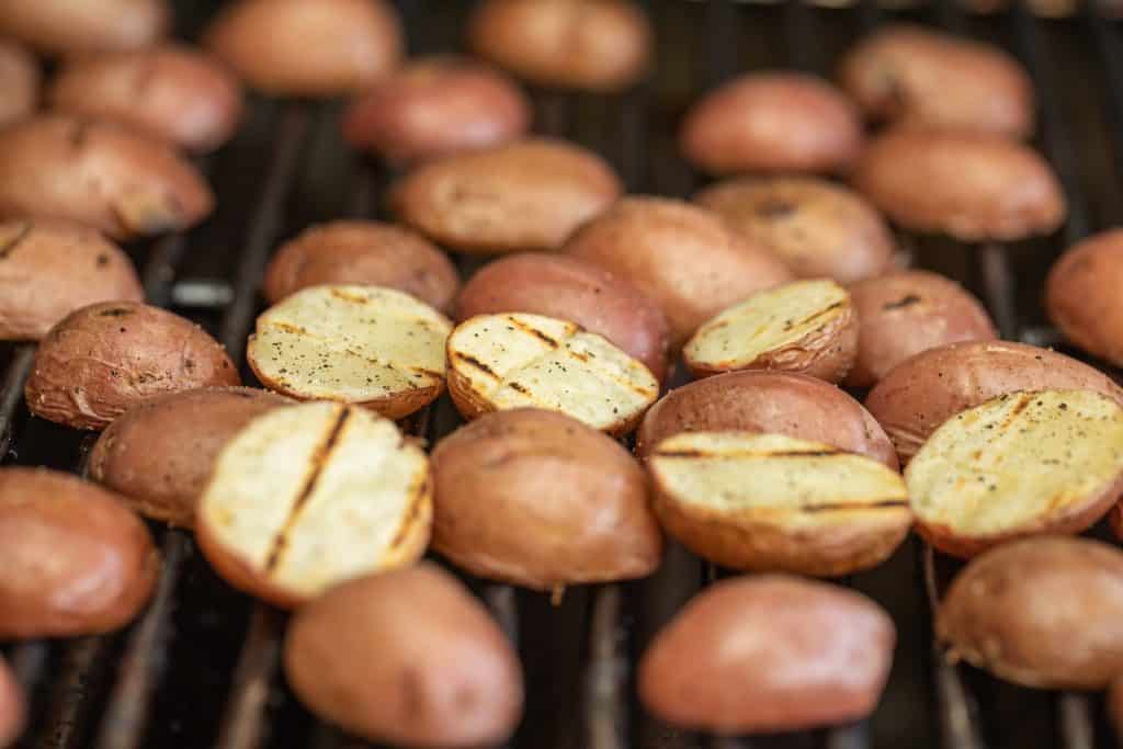 halved red potatoes on the grill.