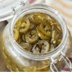 Candied jalapenos in a hinged glass jar.